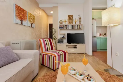 Living room with sofa, TV and a view of the kitchen. - image 4
