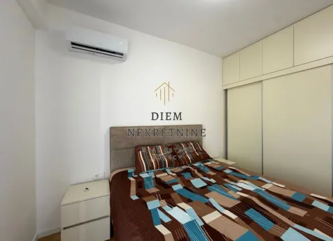 Furnished bedroom with a double bed, wardrobe, and air conditioning. - image 9
