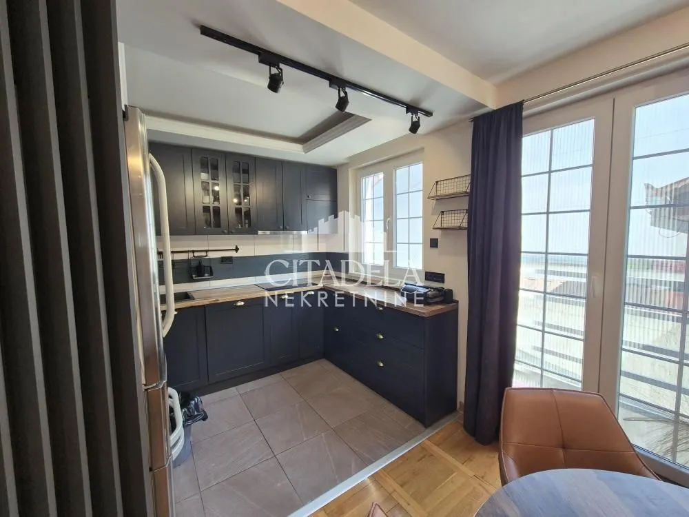 Modern kitchen with dark cabinets and a dining table.