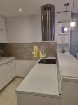 Moderna kuhinja sa belim elementima, ugrađenom pločom za kuvanje i šankom. - image 6