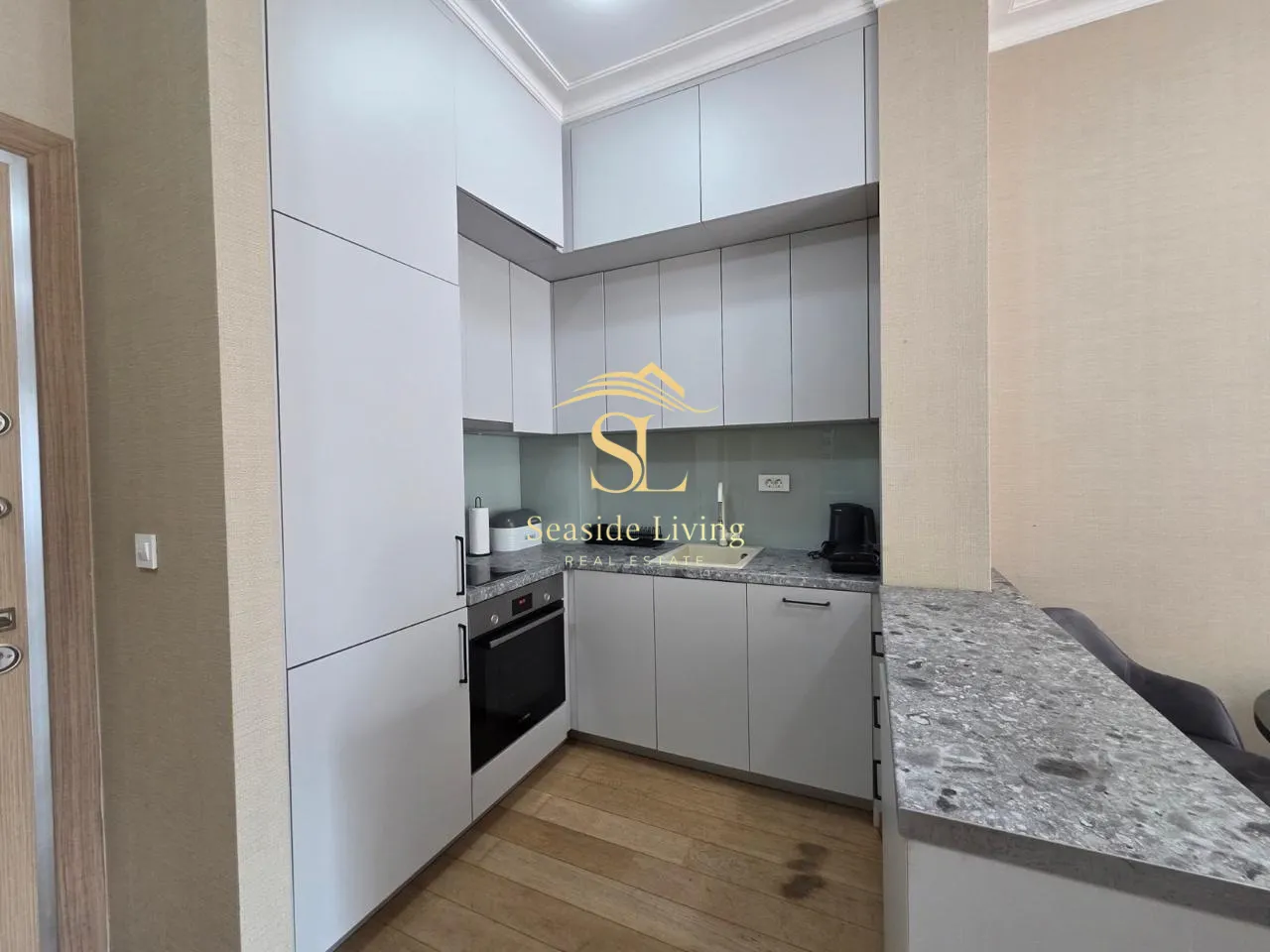 Modern kitchen with white units and a breakfast bar.