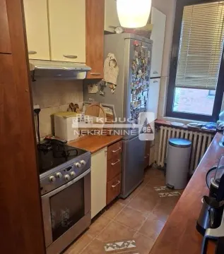 Manja kuhinja sa drvenim elementima, frižiderom i šporetom. - image 6