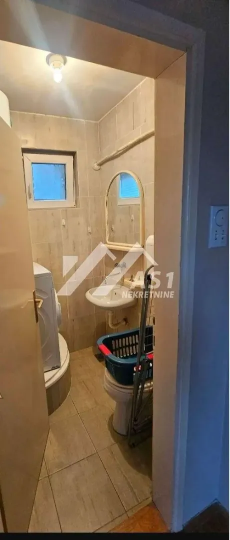 Manje kupatilo sa sanitarijama, tuš kabinom i veš mašinom.