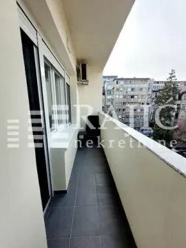 Long balcony with tiled flooring and a city view. - image 17