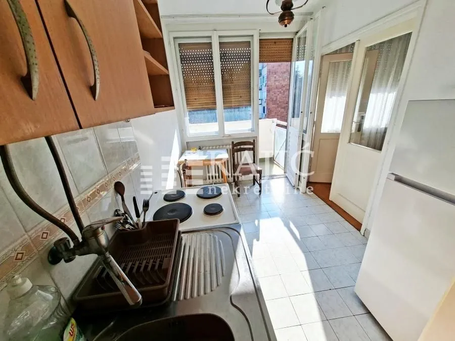 Smaller kitchen with a sink, stove, and access to the terrace.