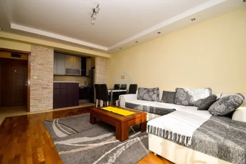 Living room with sofa, coffee table, and view of the kitchen and dining area. - image 3