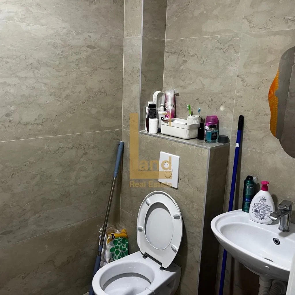 Manje opremljeno kupatilo sa sanitarijama i pločicama.