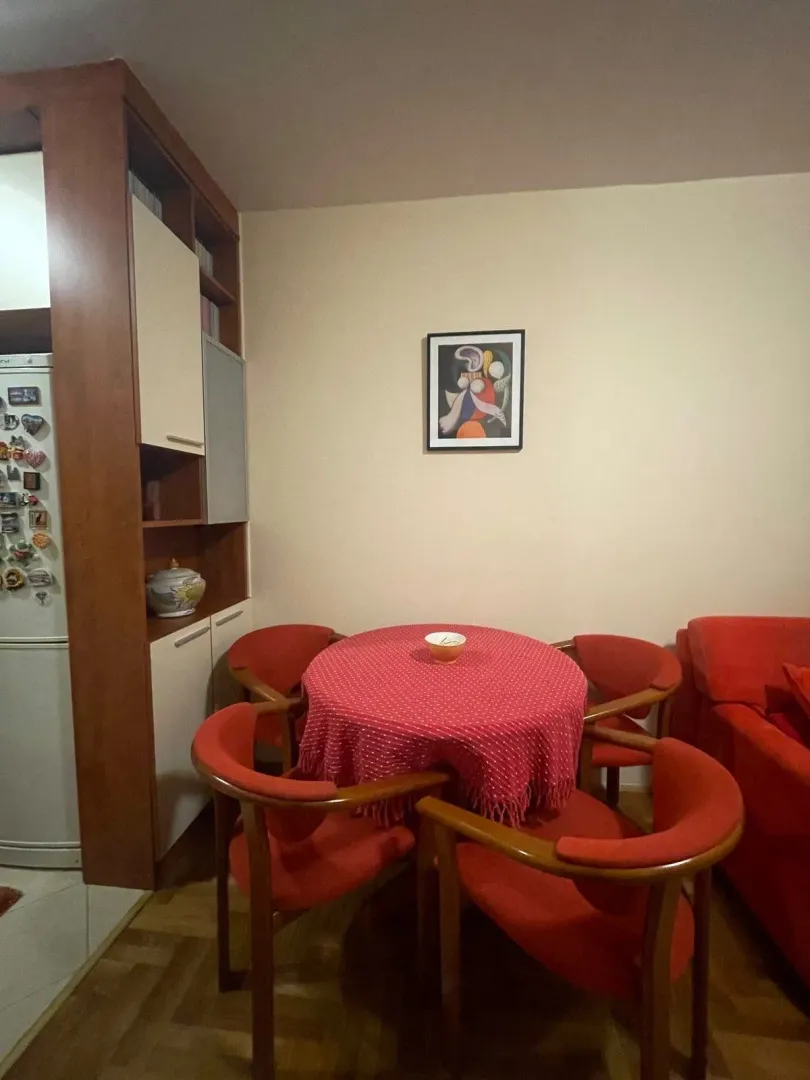 Trpezarijski sto sa crvenim stolicama u dnevnom boravku.