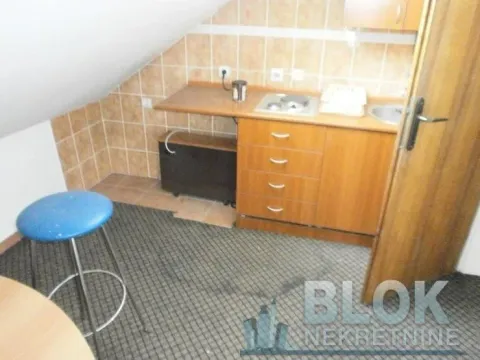 Small kitchen in the attic with wooden cabinets and tiled walls. - image 10