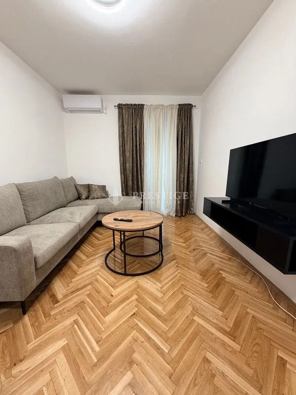 Dnevna soba sa garniturom, klub stočićem i televizorom.