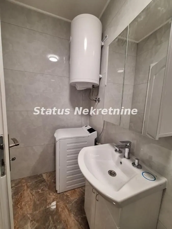 Manje kupatilo sa umivaonikom, veš mašinom i bojlerom.