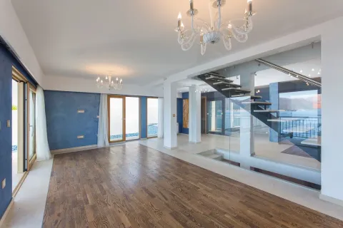 Prostran nenamješten prostor sa drvenim podom, plavim zidovima i modernim unutrašnjim stepeništem. - image 9