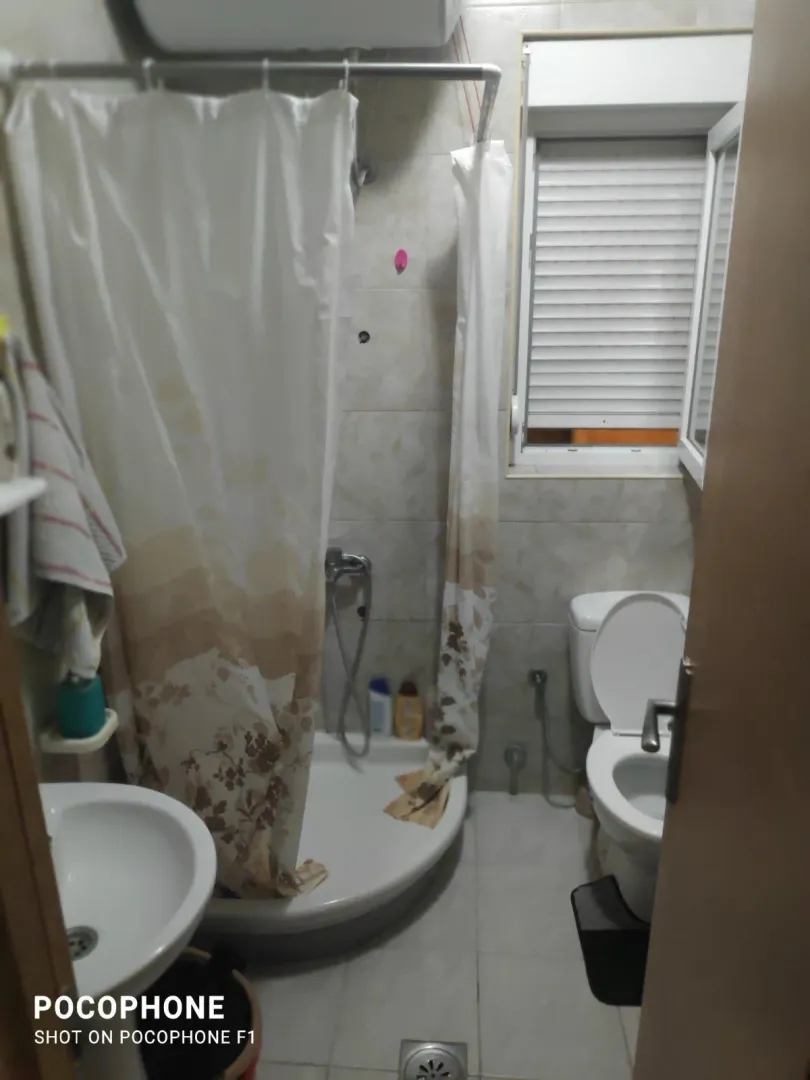 A simple bathroom with a shower cabin and a toilet.