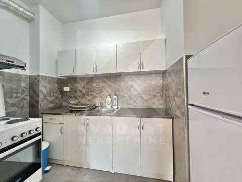 Manja kuhinja sa bijelim elementima, šporetom i frižiderom. - image 3