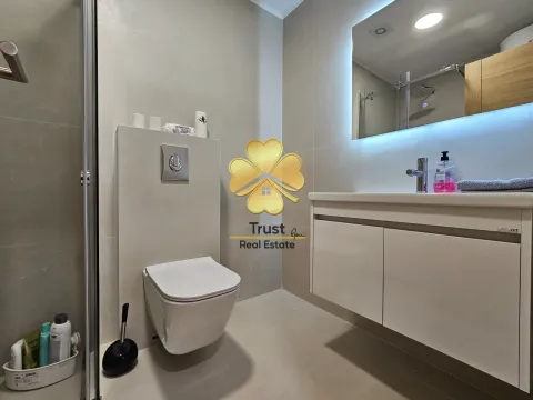 Modern bathroom with a shower cabin, wall-mounted toilet, and vanity sink. - image 8