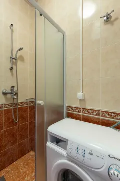 Kupatilo sa tuš kabinom i veš mašinom obloženo keramičkim pločicama. - image 8