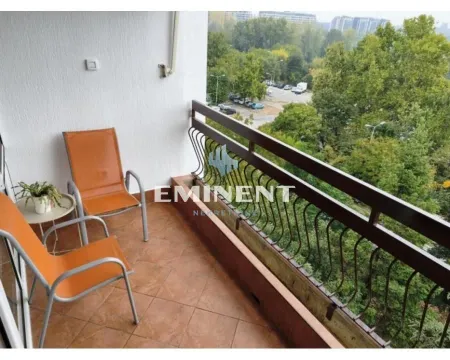 Small furnished balcony with seating furniture and a view of greenery. - image 17