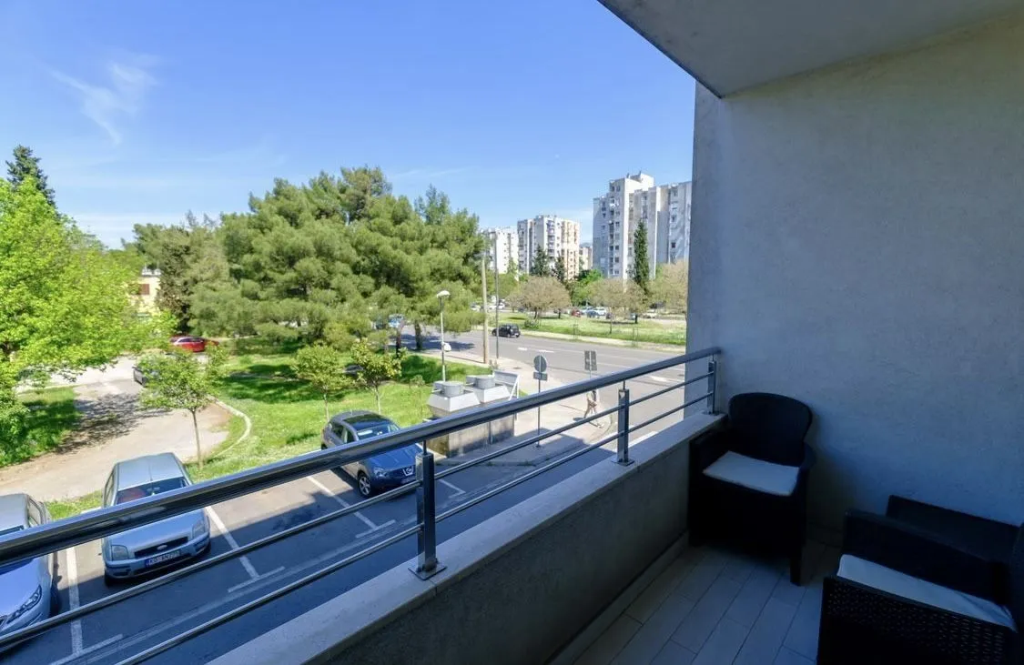 Balcony with a view of the street and park.