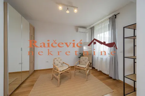 Bedroom with a large wardrobe, parquet flooring, and two armchairs. - image 16