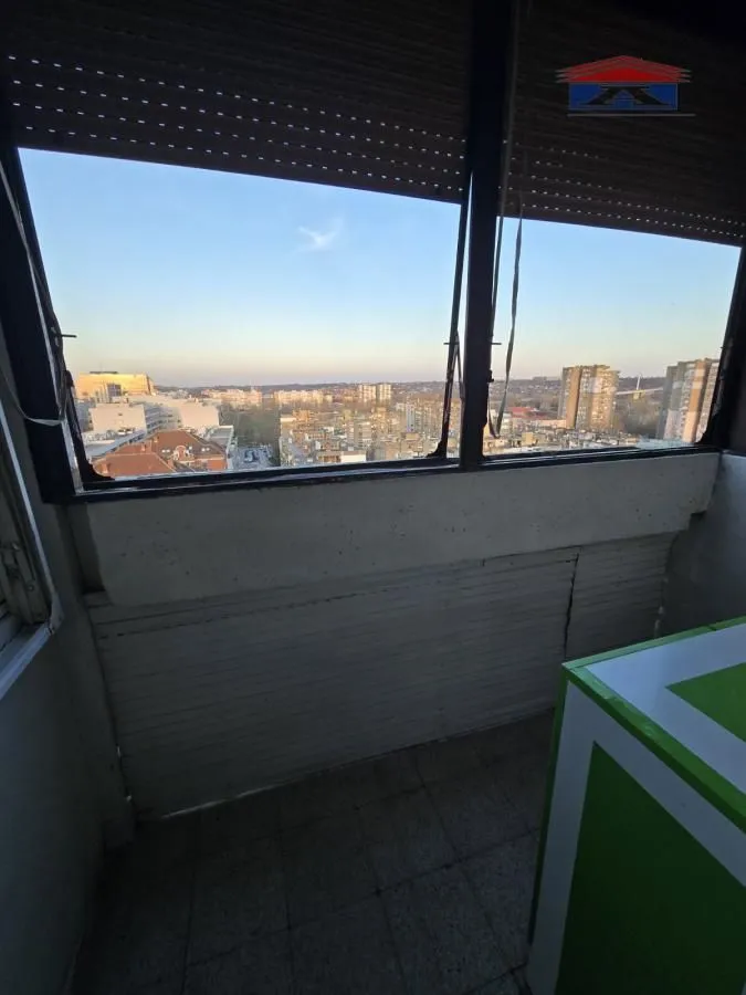 Zastakljeni balkon sa pogledom na grad.