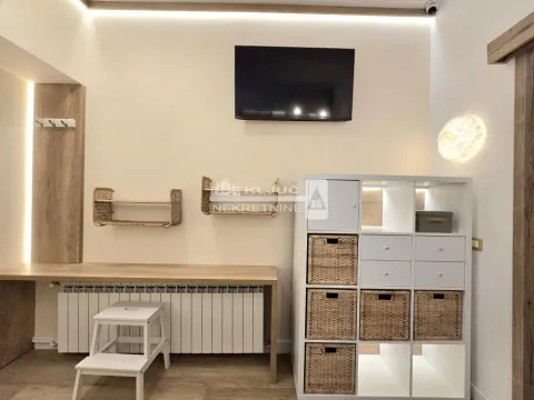 Living room with a desk and a wall-mounted TV. - image 10