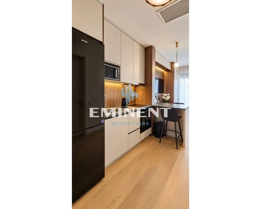 Modern kitchen with built-in cabinetry and a dining area with a breakfast bar and stools.
