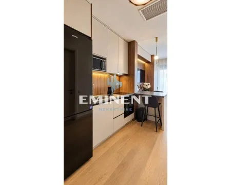 Modern kitchen with built-in cabinetry and a dining area with a breakfast bar and stools. - image 6