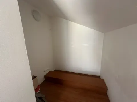 Prazan prostor u potkrovlju sa kosim plafonom i drvenim podom. - image 5