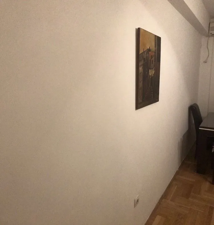 Svijetli zid sa umjetničkom slikom i detaljem trpezarije.