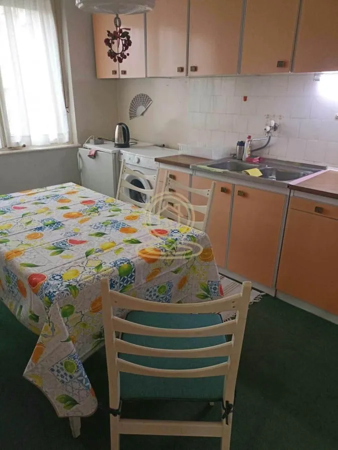Kuhinja sa trpezarijskim stolom i osnovnim elementima.