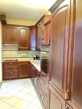Kitchen equipped with dark wooden cabinets and built-in appliances. - image 4