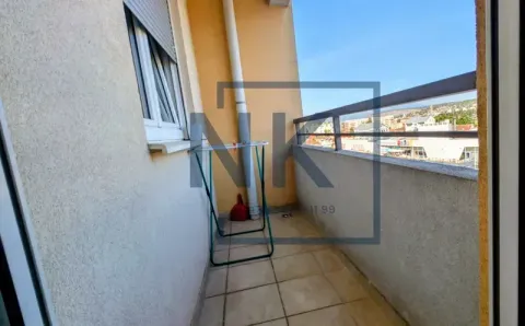 Smaller balcony with tiles and a city view. - image 16