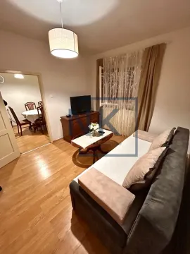 Living room with sofa, TV, and a view into the dining area. - image 3