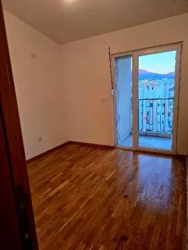 Prazna soba sa drvenim podom i izlazom na balkon. - image 6