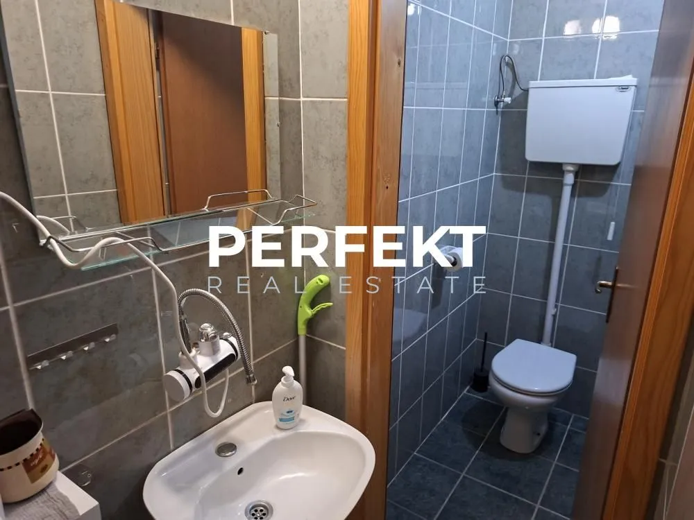 Smaller tiled bathroom with a sink and a toilet.