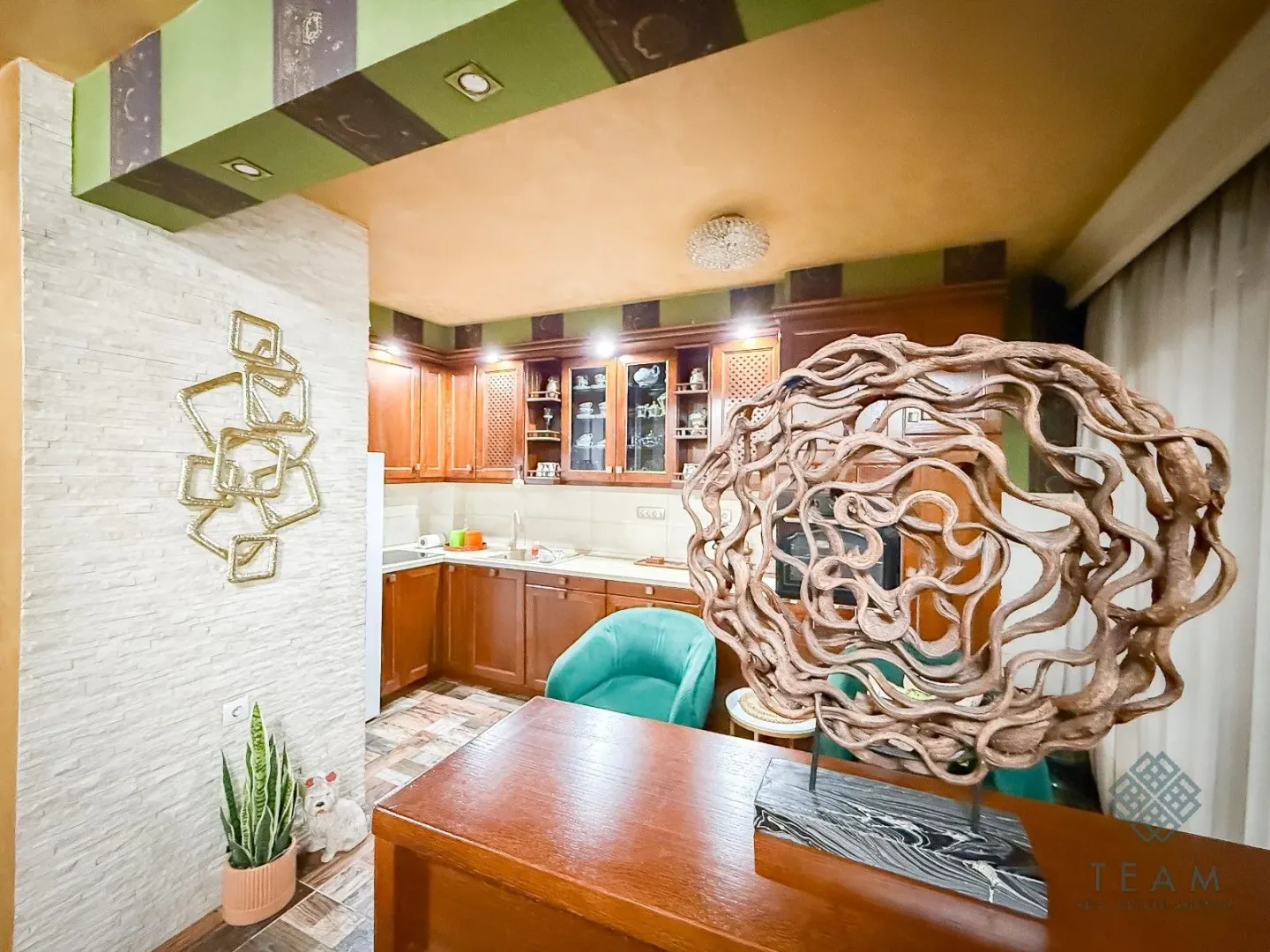 Pogled na kuhinju sa drvenim elementima i ukrasnim detaljima.