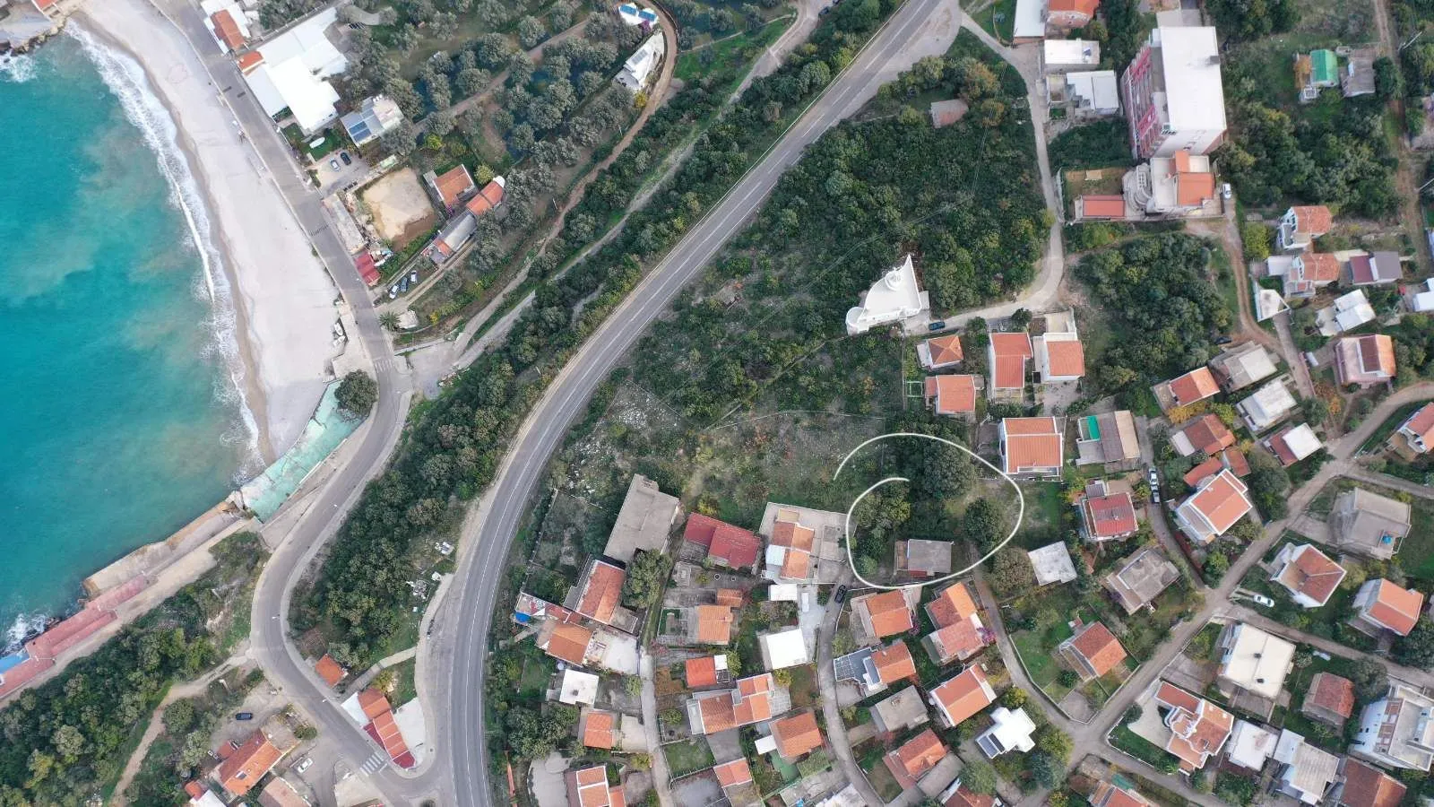 Pogled iz vazduha prikazuje lokaciju nekretnine u blizini obale i puta.