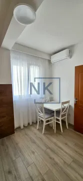 Dining area with a white table and four chairs by the window. - image 5