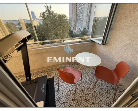 Small furnished balcony with a table, chairs, and a treadmill. - image 19