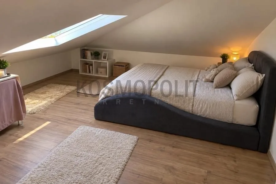 Attic bedroom with a double bed and a roof window.
