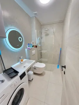 Savremeno opremljeno kupatilo sa tuš kabinom, umivaonikom, WC šoljom i mašinom za veš. - image 15