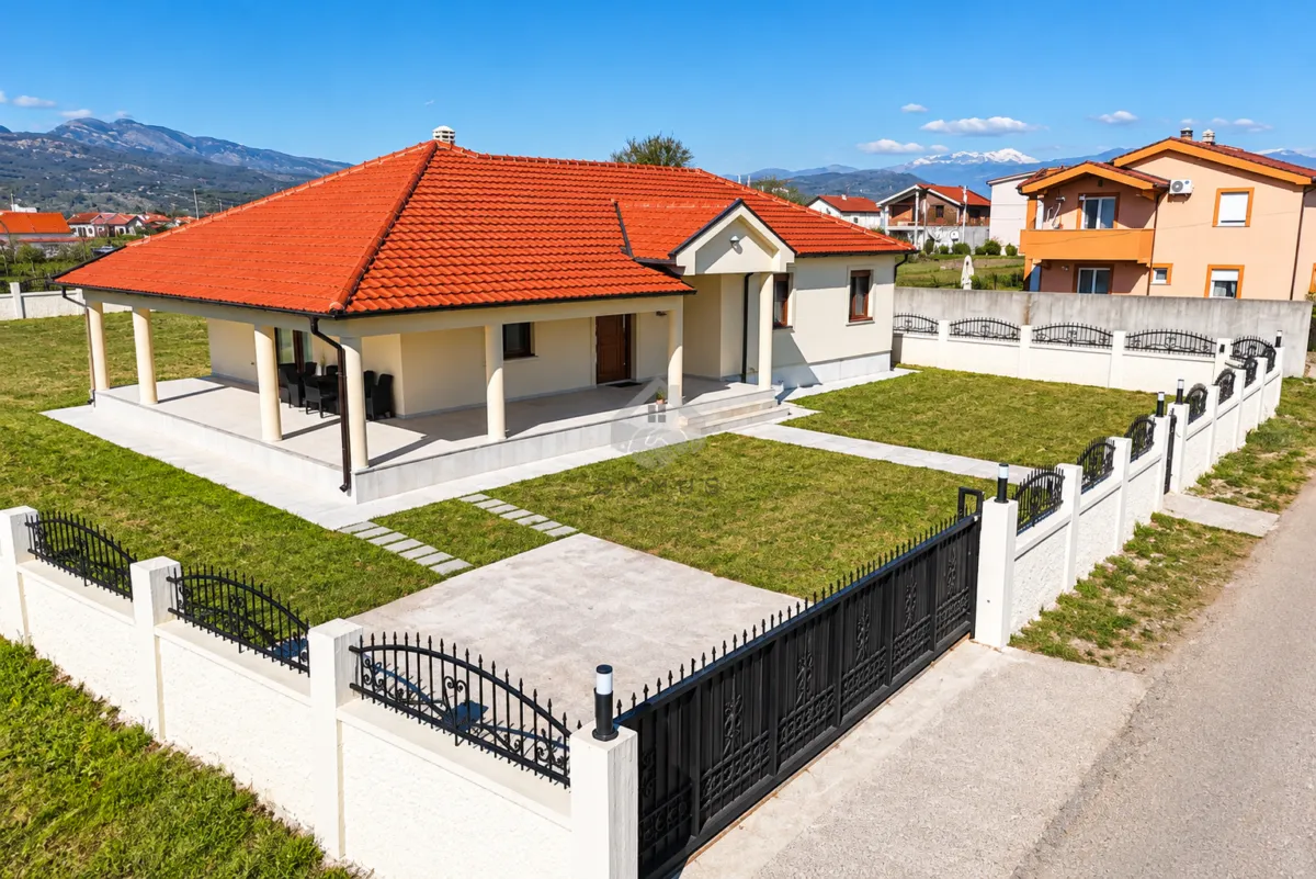 Elevated view of a single-story house with a landscaped yard and fence.