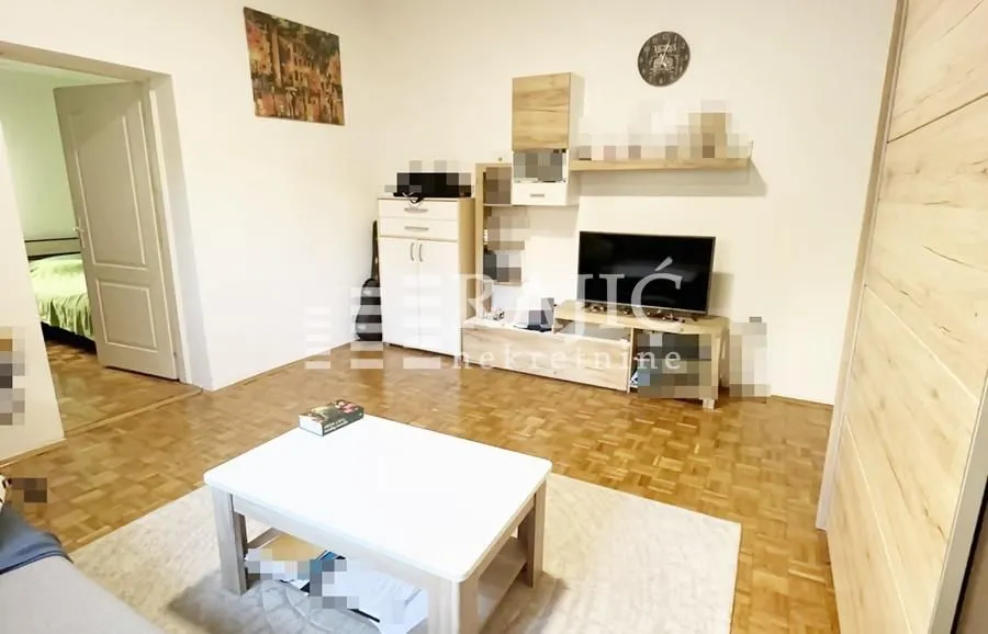 Furnished living room with a TV and wooden furniture.