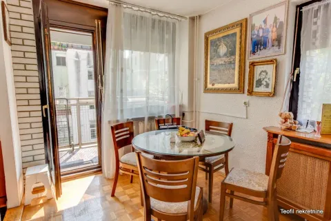 Dining area with a round table, wooden chairs, and access to the balcony. - image 5
