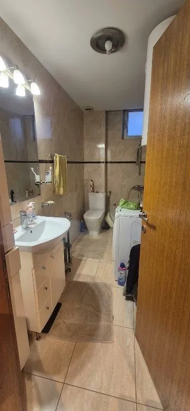 Manje kupatilo sa umivaonikom, WC šoljom i veš mašinom.