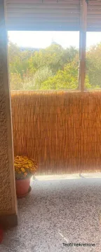 Manji natkriveni balkon sa ogradom od trske i saksijom sa cvećem. - image 7