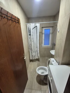 Small bathroom with a shower, toilet, and sink. - image 6
