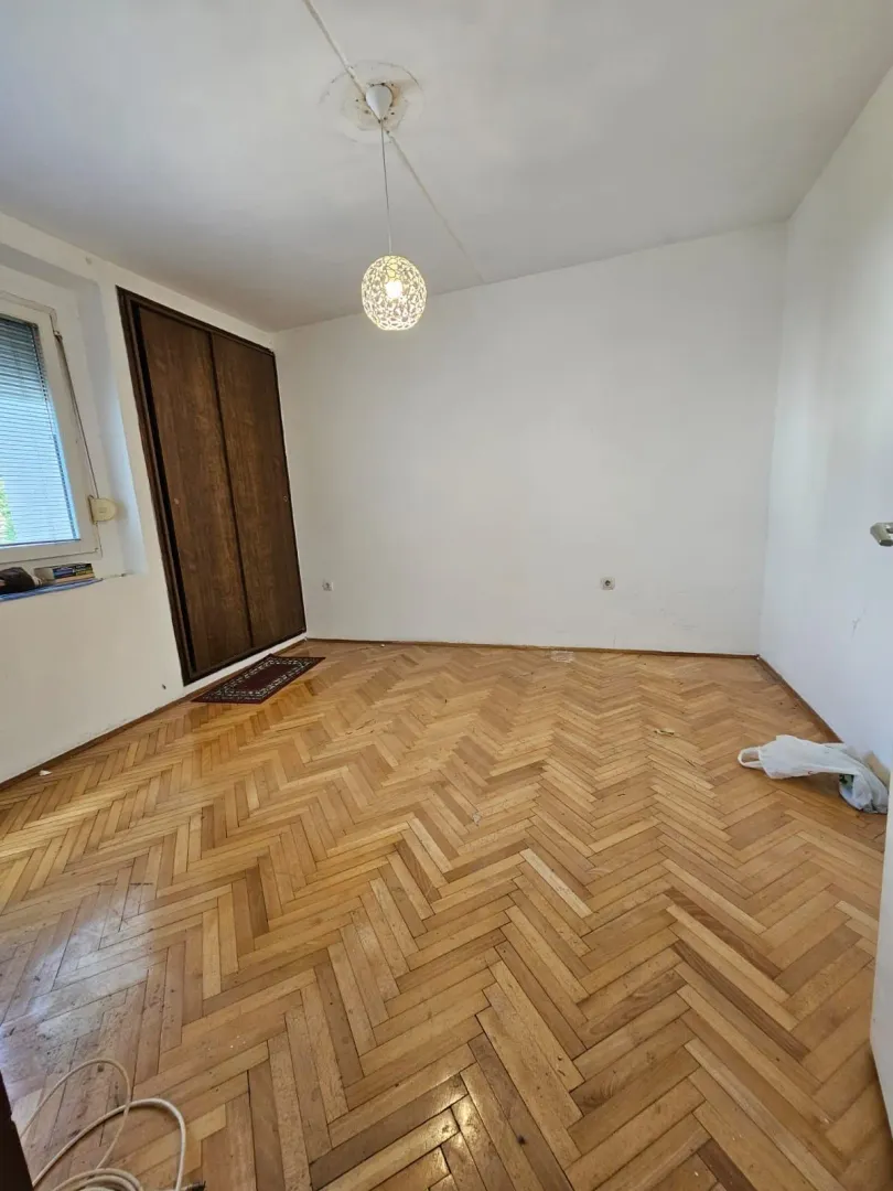 Prazna soba sa parketom i ugradnim plakarom.