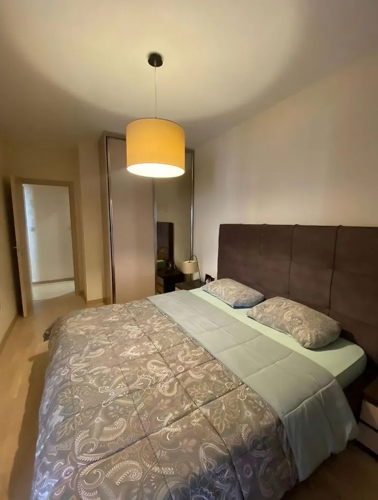 Furnished bedroom with a double bed, wardrobe, and pendant lamp.