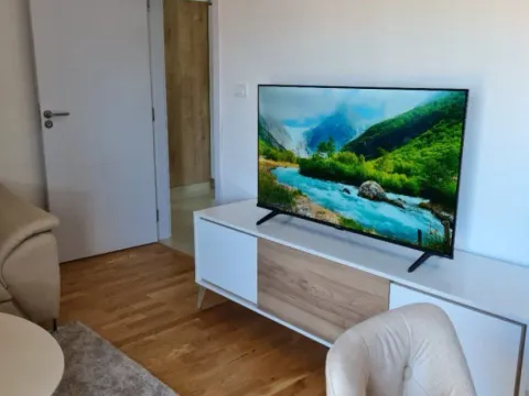 Svijetla dnevna soba sa TV komodom i drvenim podom. - image 3
